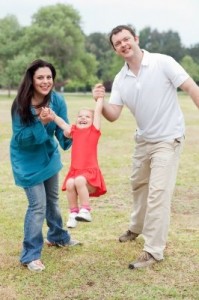 Lovely Couple Playing With Their Happy Daughter At The Park